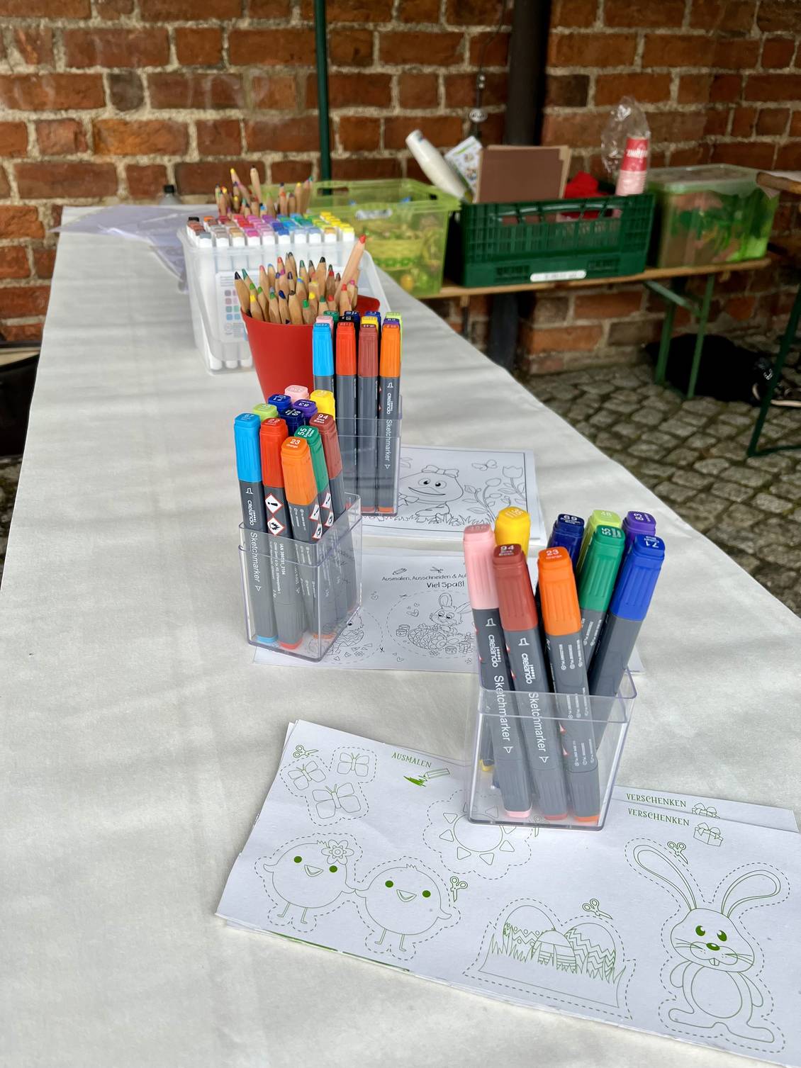 Das Foto zeigt Ausmalbilder und bunte Stifte auf einem Tisch.