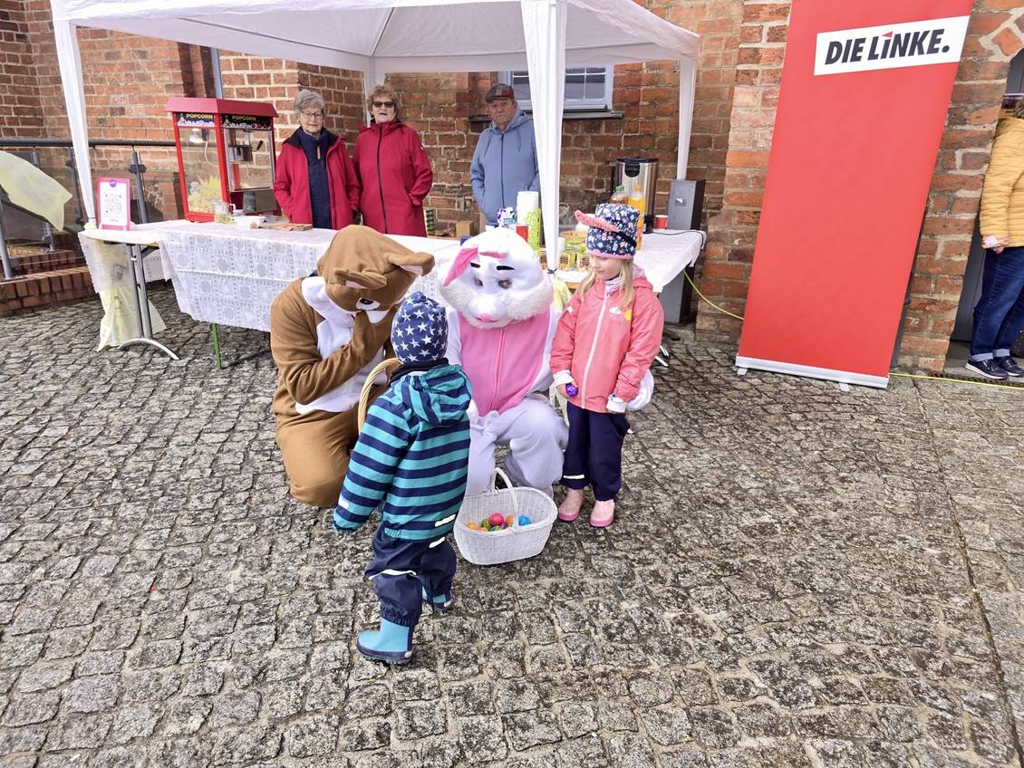 Das Foto zeigt Kinder zusammen mit Menschen, die ein Osterhasenkostüm tragen.