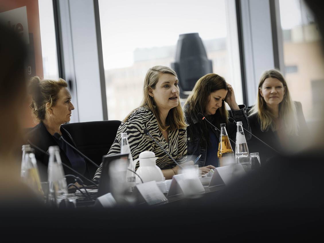 Das Foto zeigt mehrere Personen in einem Ausschusssaal des Bundestages in Berlin. 